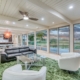 A cozy living room with a ceiling fan and a picturesque view of the golf course.