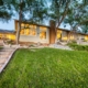 A spacious home with a vast lawn and inviting steps leading up to it, creating an elegant entrance.