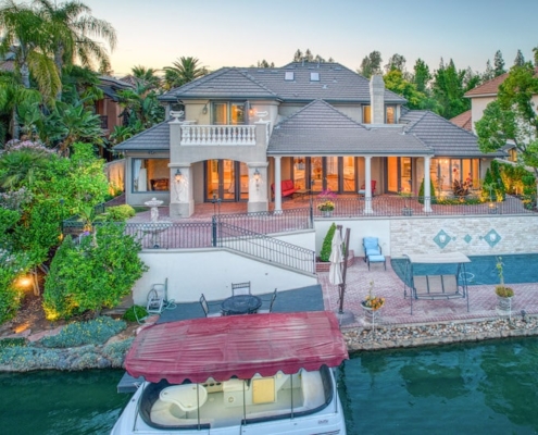 A spacious home with a boat dock and a pier by the water.