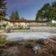 A house with a stone wall and well-maintained landscaping in front.