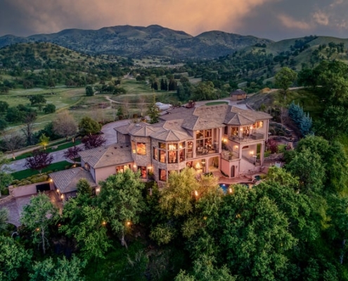 An aerial view of a spacious mountain home surrounded by breathtaking natural scenery.