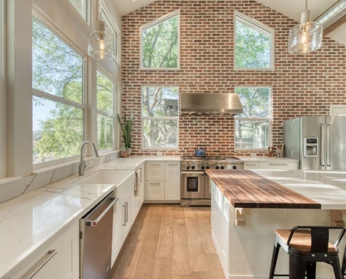 Kitchen with brick walls and a spacious island, perfect for cooking and entertaining guests.