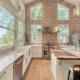 Kitchen with brick walls and a spacious island, perfect for cooking and entertaining guests.