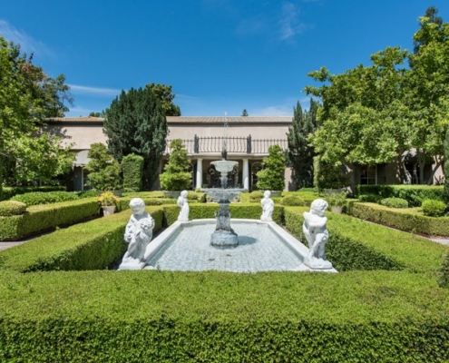 Photo of A serene garden with a beautiful fountain surrounded by neatly trimmed hedges.