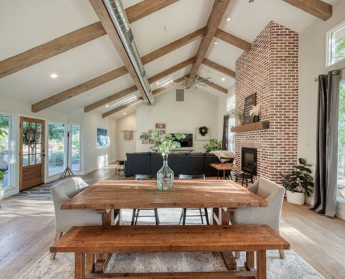 A spacious living room with a brick fireplace as the focal point.