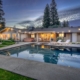 Photo of exterior view of evening lighting showing backyard with swimming pool and Jacuzzi