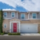 Photo of exterior front view of two story house and tall bushes by Rees Photography