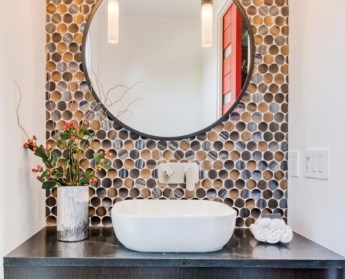 A bathroom with a black and white tile floor and a round mirror reflecting the elegant ambiance.